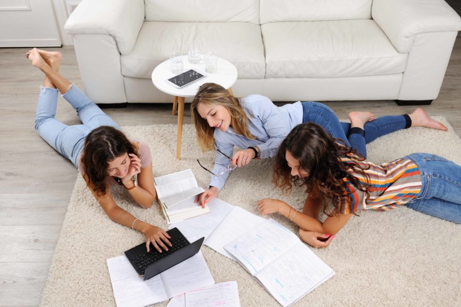 Chicas estudiando en el suelo Habitaciones para universitarios Unihabit scaled 900x600 1